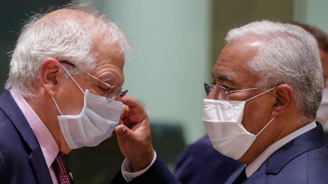 El primer ministro portugués, Antonio Costa, ajusta la mascarilla al jefe de la diplomacia europea, Josep Borell.