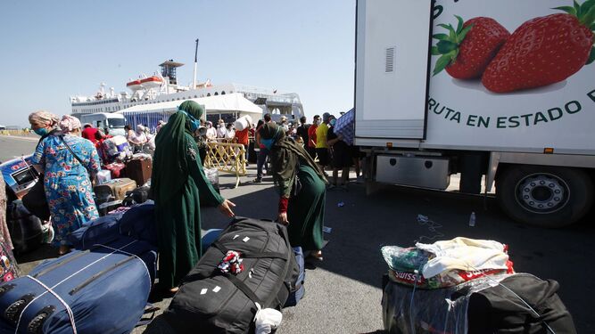 Temporeras marroquíes recogen sus maletas antes de subir en el ferry en el que viajan al puerto de Tánger