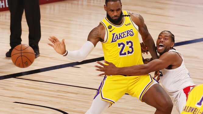 LeBron James, decisivo para el triunfo de los Lakers, se impone a Kawhi Leonard en una acción del partido.