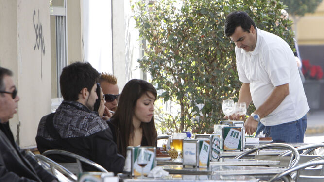 Un camarero  atiende una mesa en una terraza