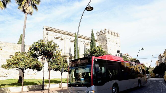 Un autobús urbano circula junto al Alcázar.