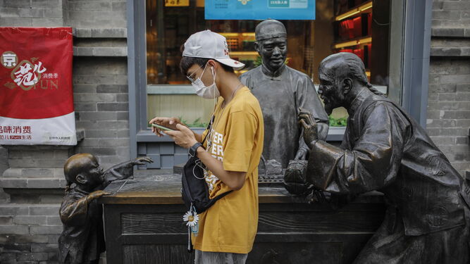 Un joven con mascarilla en Pekín.