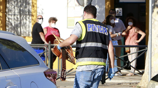 Un agente con los restos de la guitarra que al parecer provocó la discusión y el homicidio.