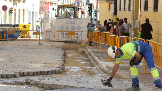 Colas en Correos junto a las obras que delimitan las obras de renovación del saneamiento en la calle Cerrón.