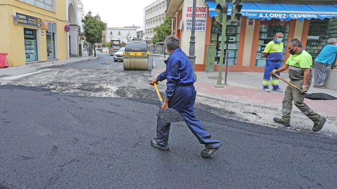 Operarios cubren con alquitrán el pasado martes la base de hormigón de la calle Corredera, medida provisional ejecutada por el Ayuntamiento en previsión de la llegada de las primeras lluvias fuertes.