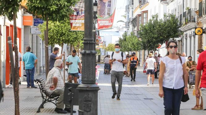 Gente con mascarillas por la céntrica calle La Plaza de Chiclana.
