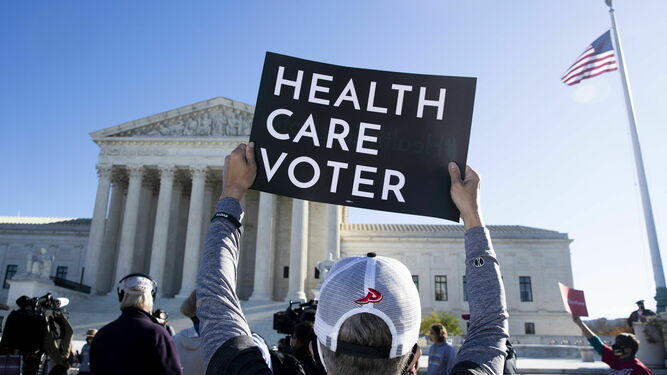 Varias personas protestan ayer fuera del Tribunal Supremo en Washington a favor del 'Obamacare'.