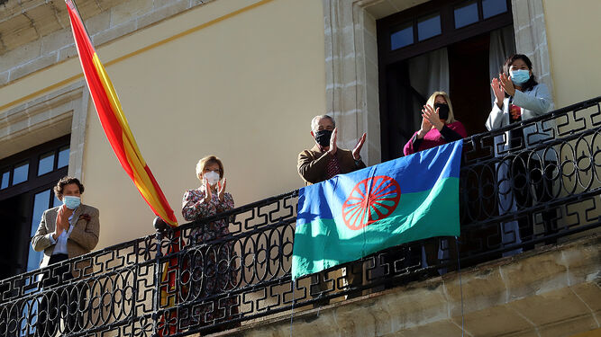 Imagen de la colocación de la bandera del Pueblo Gitano en el balcón principal del Ayuntamiento.