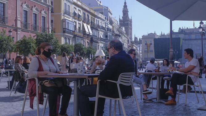 Varias personas toman algo en una terraza del centro de Sevilla.