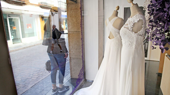 Una mujer mira vestidos de novia en un escaparate.