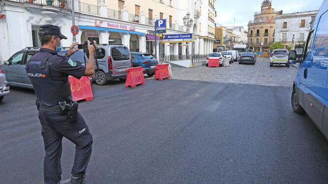 Un agente autonómica toma fotografías de la plaza Esteve tras su asfaltado para su apertura provisional al tráfico.