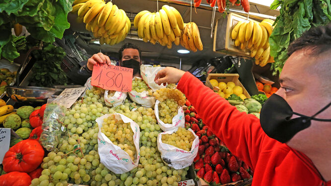 Un cliente comprando uvas este miércoles en el mercado central de abastos de Jerez.