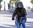 Una mujer en bicicleta en una gélida mañana en Sevilla.