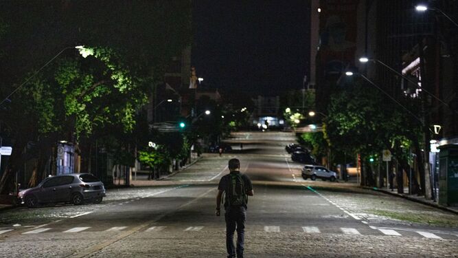 Un hombre caminando solo por una calle vacía.