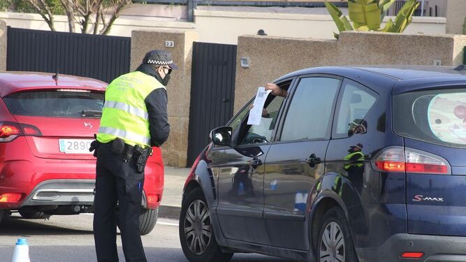 Un conductor muestra la documentación a un policía en un control a la entrada de Jerez.