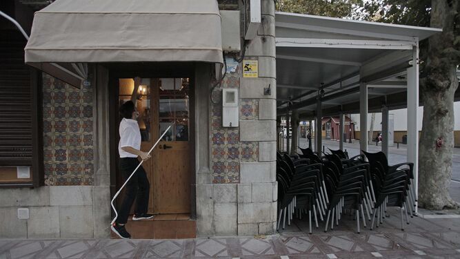 El empleado de un bar de La Línea de la Concepción cierra el establecimiento por las medidas del coronavirus.