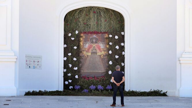 Una foto con la Virgen del Rocío vestida de Pastora presidía la puerta del santuario en vísperas de Pentecostés de 2020.