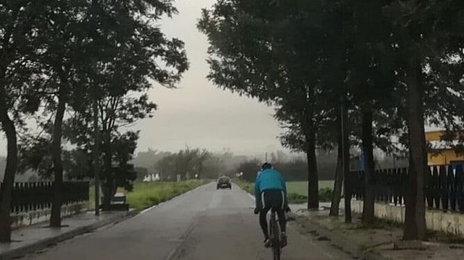 Un ciclista pedaleando en una barriada rural de Jerez