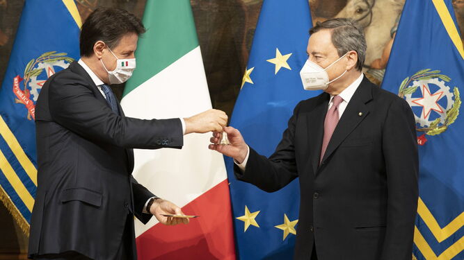 El nuevo primer ministro italiano, Mario Draghi (dcha.), recibiendo este sábado una pequeña campana del primer ministro saliente, Giuseppe Conte.