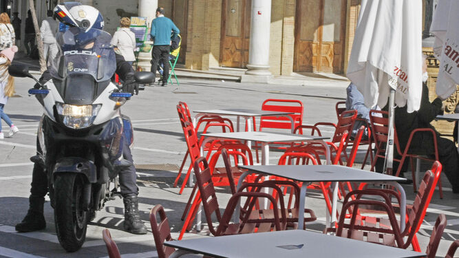 Un policía motorizado controla el cierre de terrazas en el centro de Jerez.
