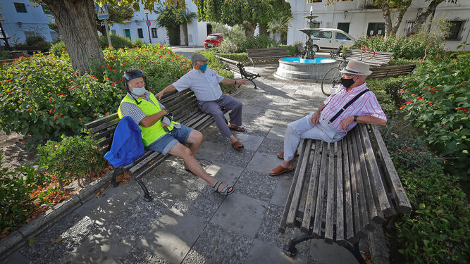 Tres hombres mayores descansan en unos bancos en La Barca de la Florida.
