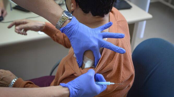 Una enfermera coloca el algodón en el brazo de una persona justo tras haber recibido el pinchazo de AstraZeneca.
