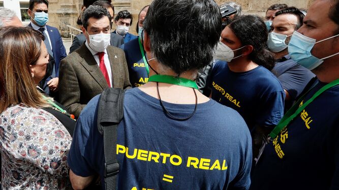 El presidente de la Junta, Juanma Moreno, atiende a los miembros del comité de Airbus Puerto Real en el Parlamento.