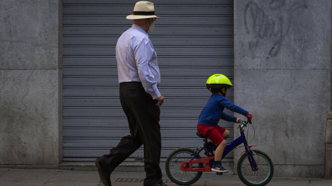 La actividad física es esencial frente al sobrepeso. Un niño pasea en bici con un familiar.