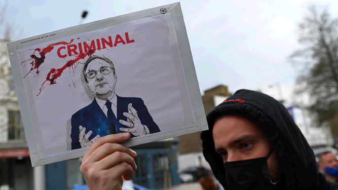 Un aficionado del Chelsea protesta contra la Superliga con una pancarta en la que llama "criminal" a Florentino Pérez.