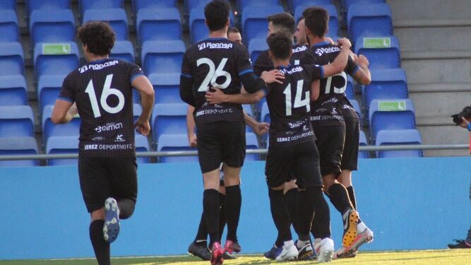 Los jugadores del Xerez DFC felicitan a su compañero Antonio Sánchez tras anotar de penalti.