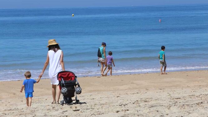 Personas paseando por la playa de La Barrosa, en una imagen de archivo.