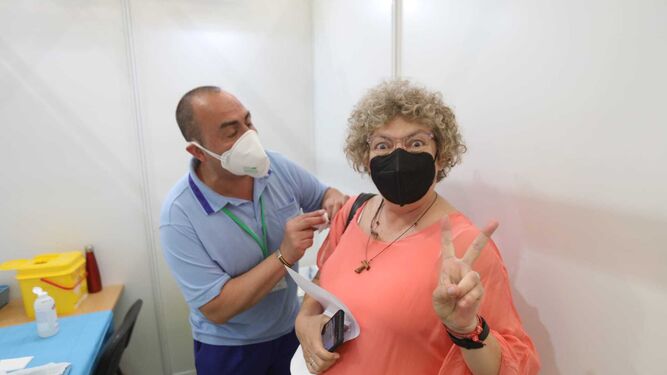Una mujer hace el signo de la victoria tras ser inoculada este martes con la vacuna de Pfizer en el polideportivo Vega Veguita.