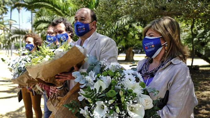 La delegada de Salud, el director del hospital y el alcalde con los ramos de flores que depositaron en el Árbol de la Solidaridad.