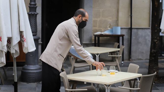 Un camarero recoge un servicio en un bar del centro de Jerez.