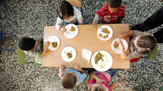Grupo de alumnos almorzando en un comedor escolar.