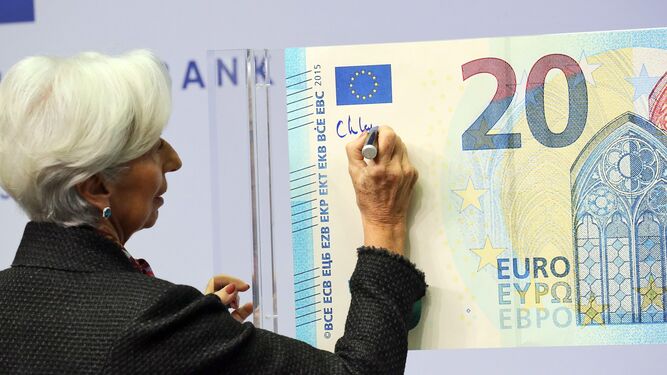 Christine Lagarde firma un billete gigante de 20 euros