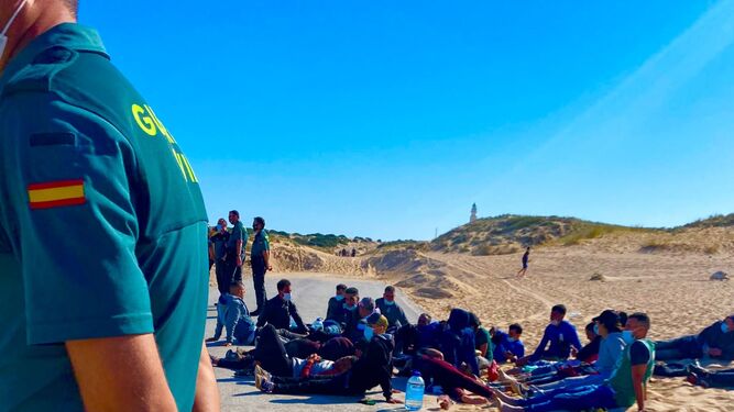 Varios agentes de la Guardia Civil custodian a los migrantes que llegaron a la playa de Los Caños de Meca.