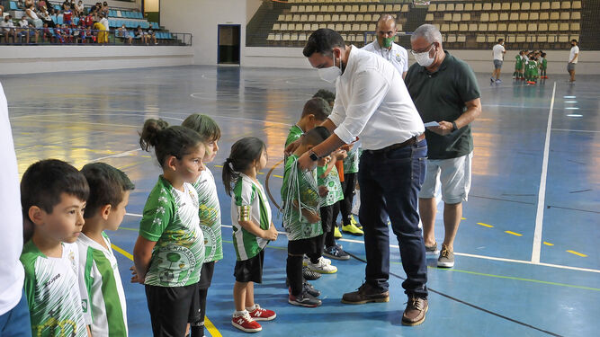 Jesús Alba y Diego Osorio entregan a los niños sus medallas.