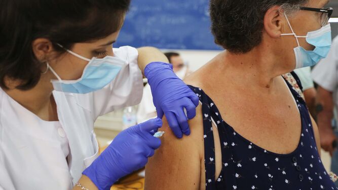Una sanitaria vacuna a una mujer, en el campus universitario.
