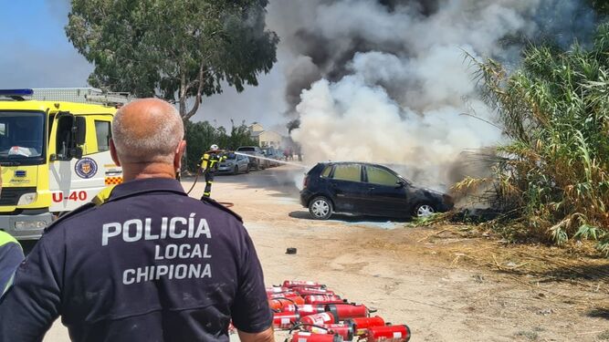 Un momento de la extinción del incendio de varios vehículos en una playa de Chipiona.