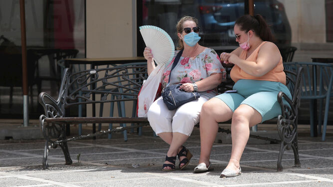 Dos mujeres toman un respiro en un banco en el centro de Jerez