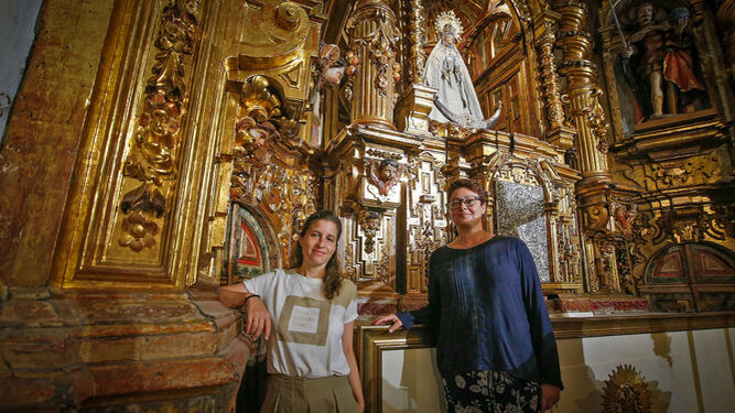 Cristina Espejo y Pepa Segura posan junto al retablo de San Lucas.