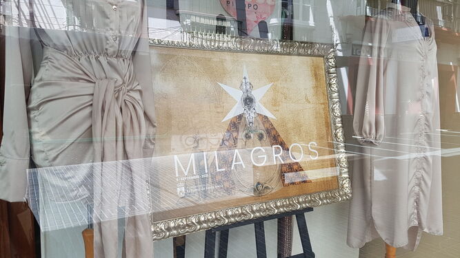 Uno de los escaparates de un comercio del centro de la ciudad, con el cartel de la Virgen de los Milagros.
