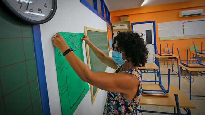 Una docente, preparando el aula de un centro educativo.