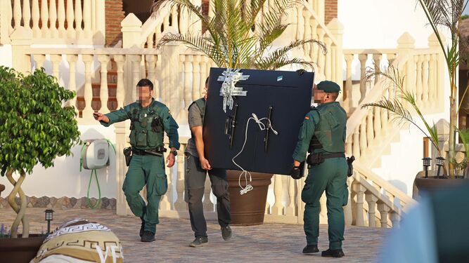 Dos agentes portan un gran televisor intervenido durante la Operación Tortilla, desarrollada en el Campo de Gibraltar.