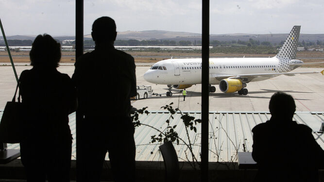 Varias personas observan los movimientos de un avión en la pista del Aeropuerto de Jerez.