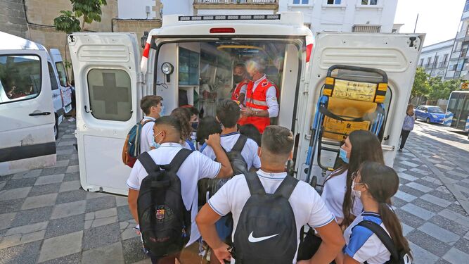 Miembros de la Cruz Roja, enseñando a escolares el interior de una ambulancia.