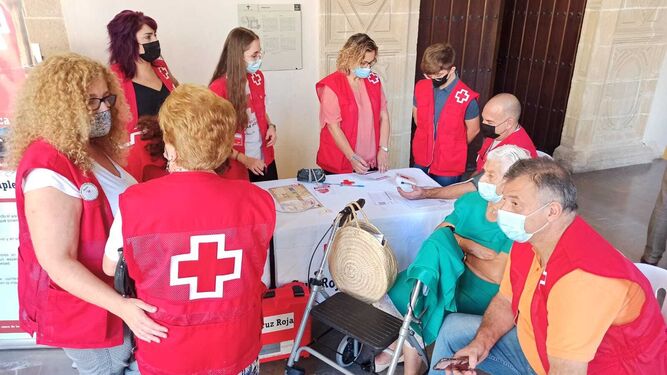 Personal de Cruz Roja, en una de las mesas de los Claustros.