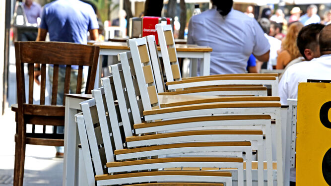 Imagen de sillas apiladas en una terraza de la ciudad.