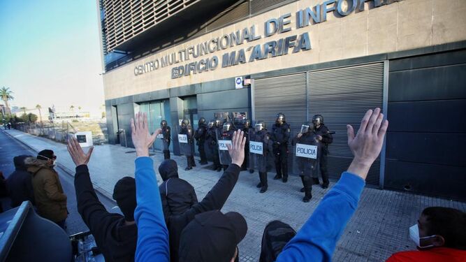 Manifestantes ante la sede de la Confederación de Empresarios de Cádiz, protegida por la Policía.